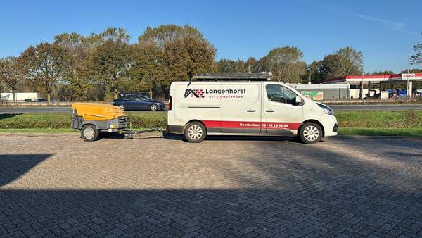 De bedrijfsbus van Langenhorst Gevelonderhoud met aanhanger