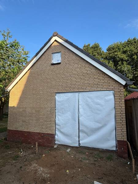 Garage van gele steen met rode plint
