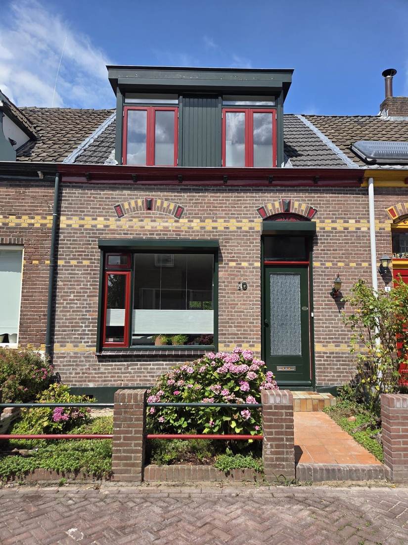 Woning met sierlijsten van gele en rode steen in het metselwerk