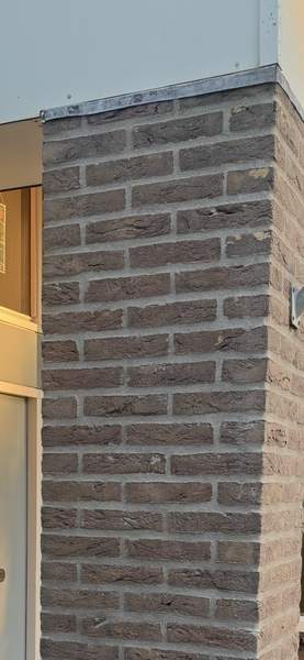 Smal gemetseld penant naast een deur