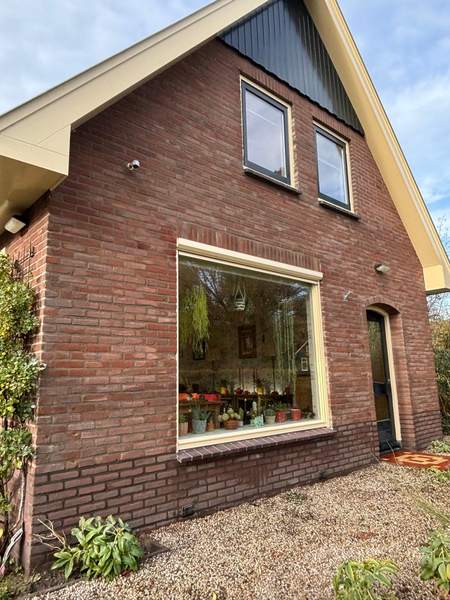 Zijgevel van dezelfde woning met groot raam