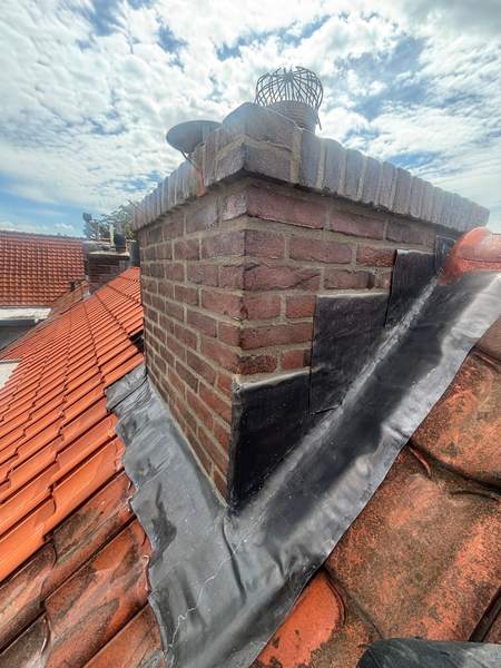 Schoorsteen met lood op een rood pannendak