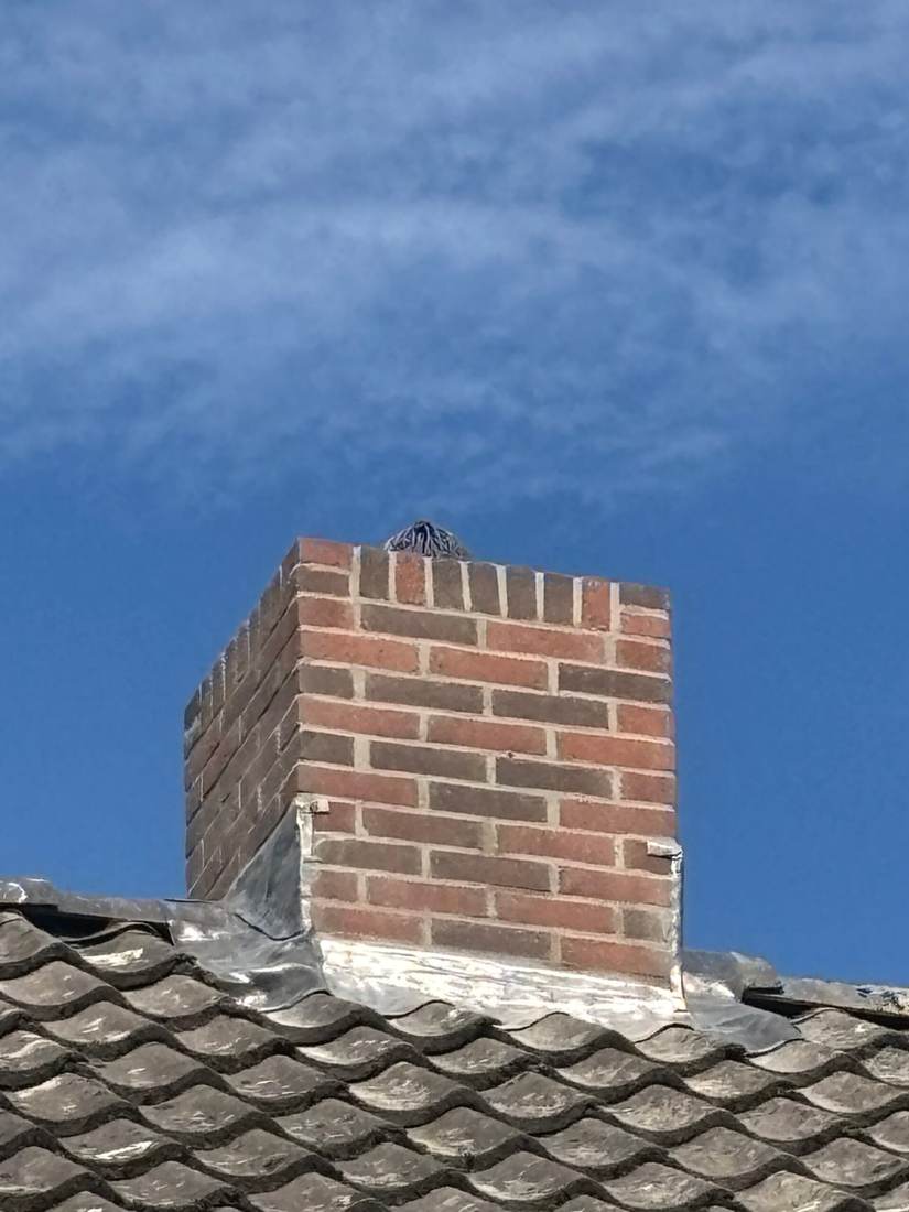De schoorsteen na het werk, tegen een blauwe lucht