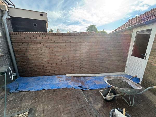 Tuinmuur in aanbouw, met kruiwagen